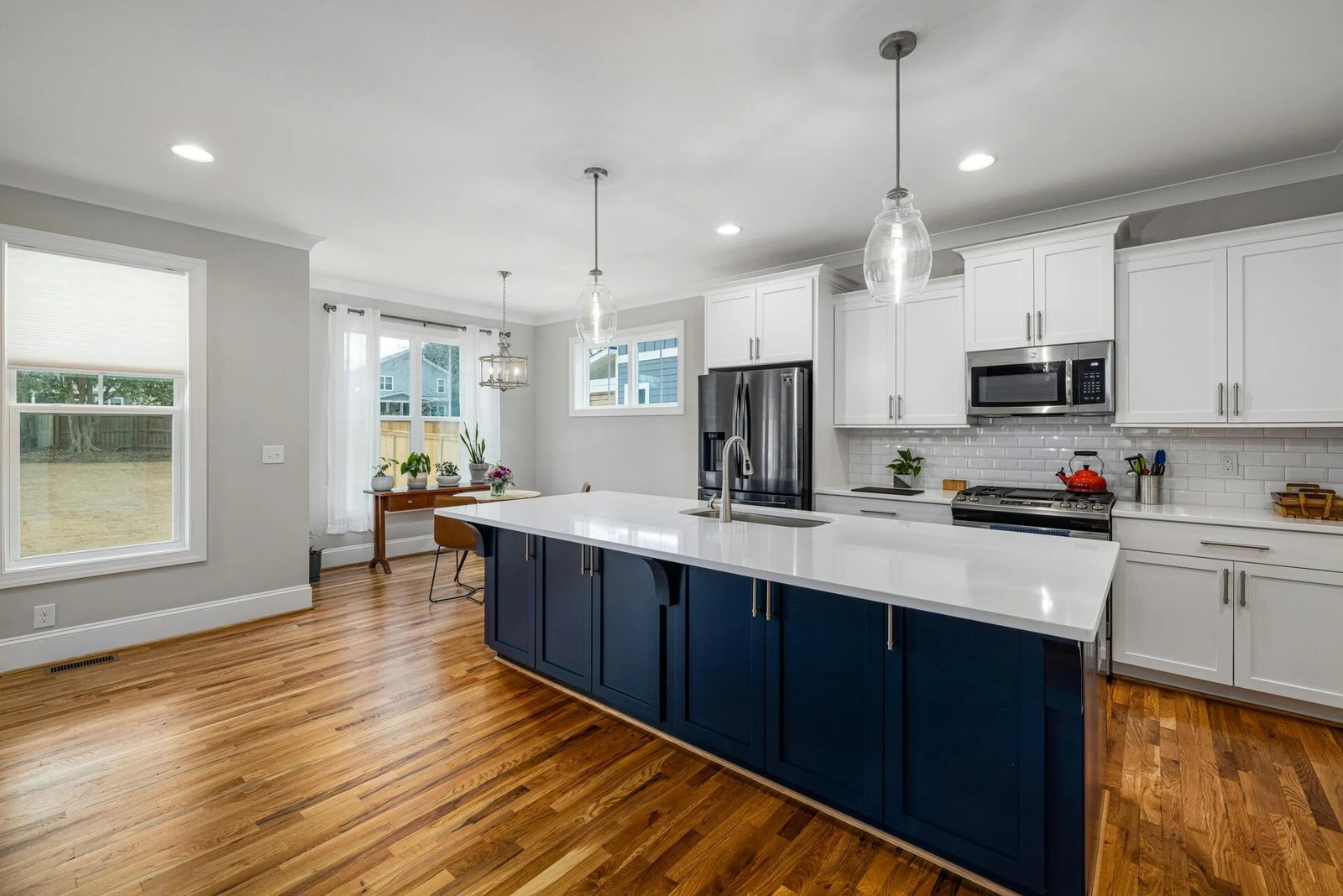 Kitchen after cabinet refacing: white uppers and a navy island